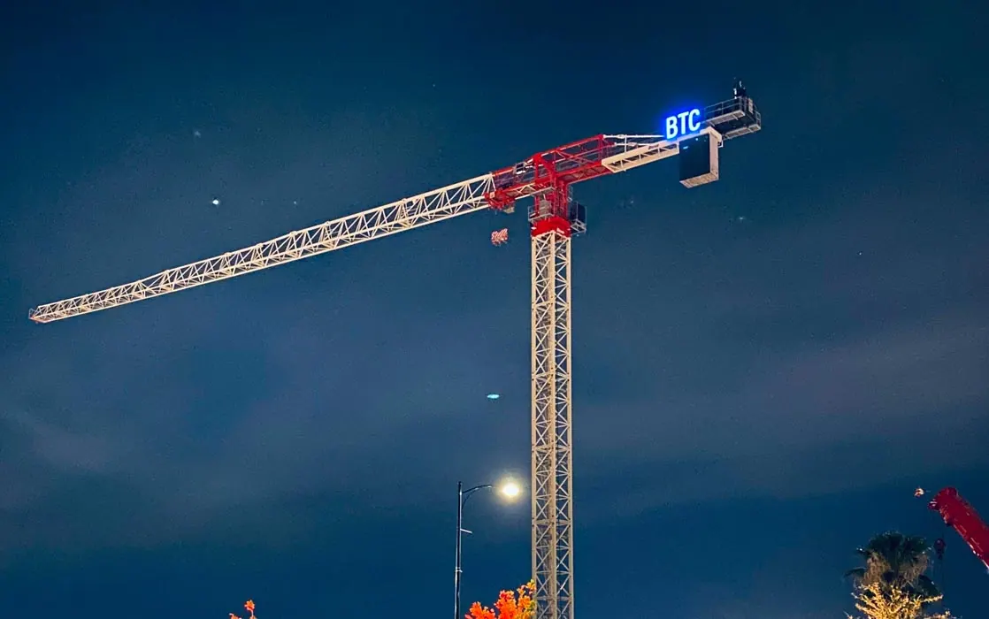 BTC tower crane on a school construction site at night